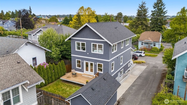 back of property featuring fence, a deck, a residential view, and french doors