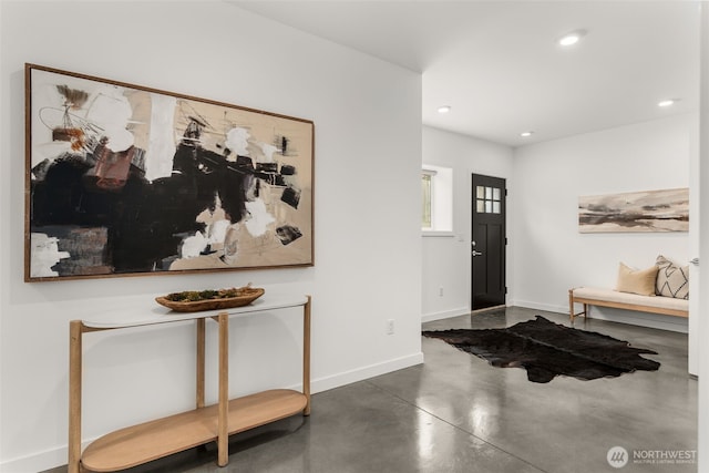 foyer entrance featuring concrete floors, baseboards, and recessed lighting