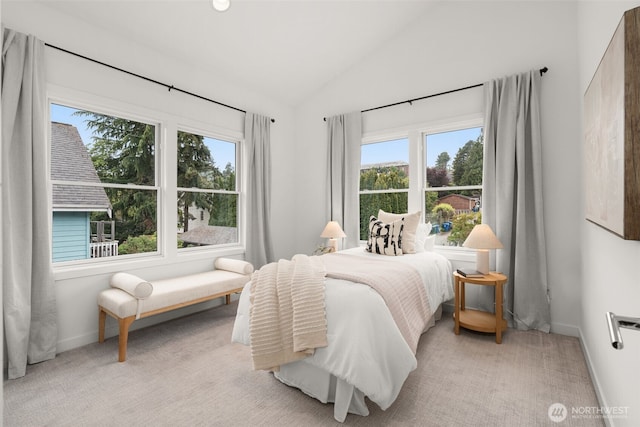 bedroom with lofted ceiling, baseboards, and light colored carpet