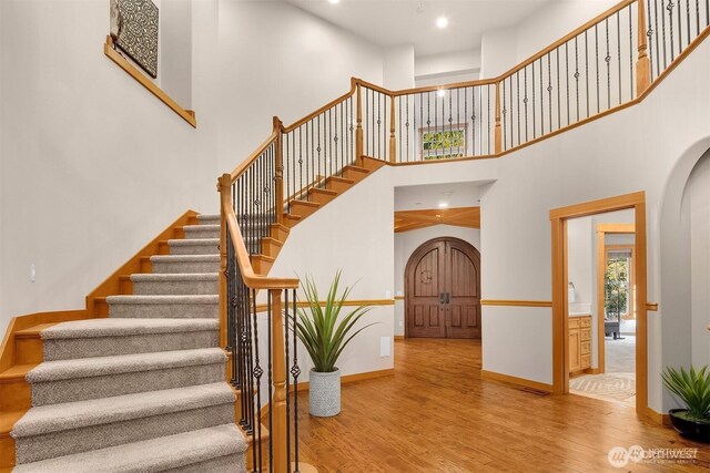 25935 SE 235th Way, Maple Valley, WA 98038 - foyer entrance with arched walkways, stairway, a high ceiling, wood finished floors, and baseboards