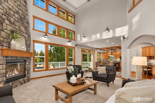 25935 SE 235th Way, Maple Valley, WA 98038 - living room featuring baseboards, arched walkways, light carpet, and a fireplace