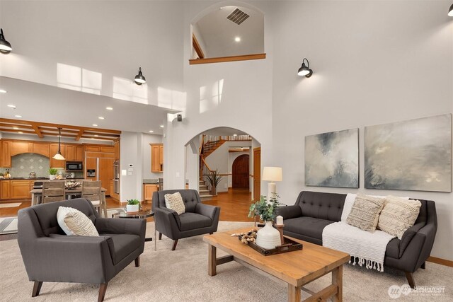 25935 SE 235th Way, Maple Valley, WA 98038 - living area with visible vents, arched walkways, beamed ceiling, recessed lighting, and stairs