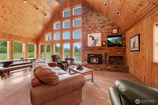 carpeted living room featuring wood walls, tile patterned floors, high vaulted ceiling, and wood ceiling