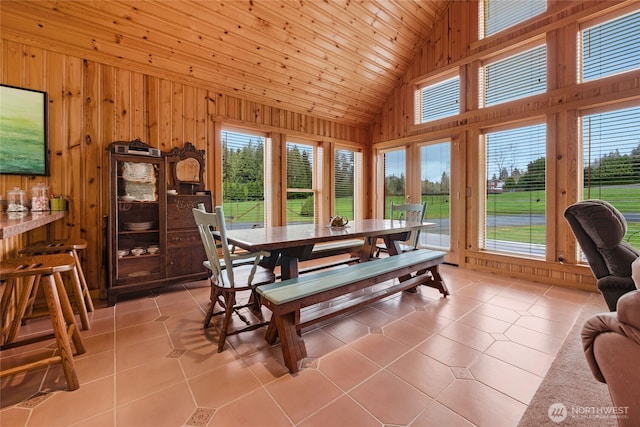 dining room with wood ceiling, wood walls, and light tile patterned flooring