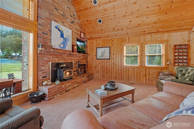living room with a wood stove, high vaulted ceiling, wood ceiling, carpet flooring, and wooden walls