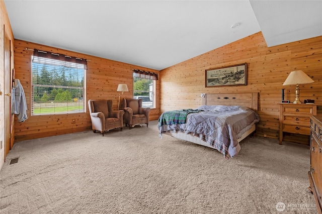 bedroom featuring carpet, visible vents, wooden walls, and lofted ceiling