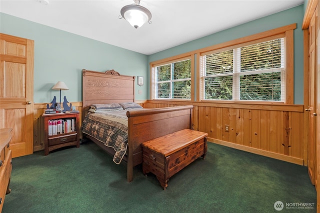 bedroom with wooden walls, carpet, and a wainscoted wall