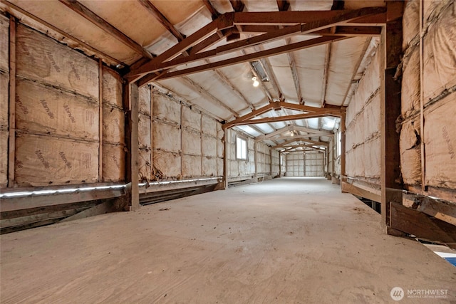 misc room featuring a garage and lofted ceiling