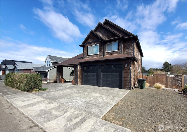 craftsman inspired home featuring concrete driveway, fence, and an attached garage