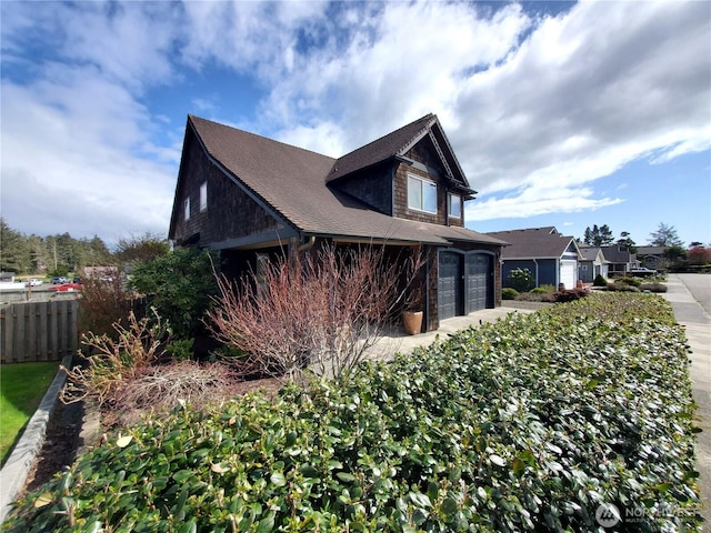 view of side of home with a garage and fence