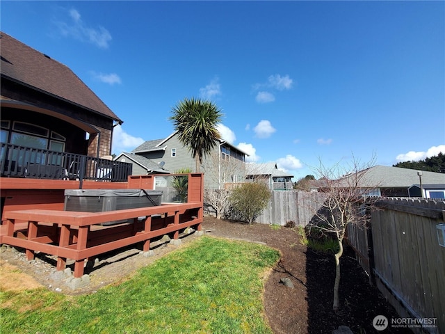 view of yard featuring a fenced backyard, a wooden deck, and a hot tub