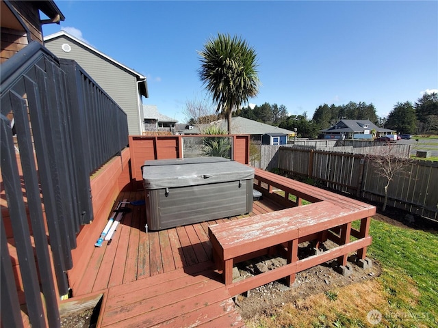 wooden terrace with a hot tub and fence