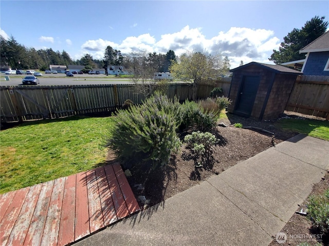 view of yard with a fenced backyard, a shed, and an outdoor structure