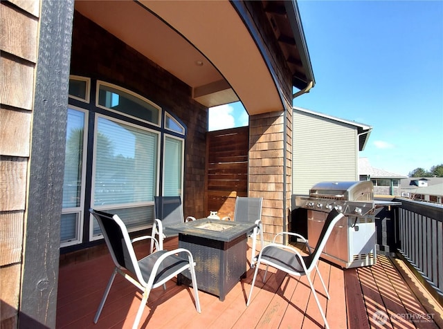 wooden deck with grilling area and a fire pit