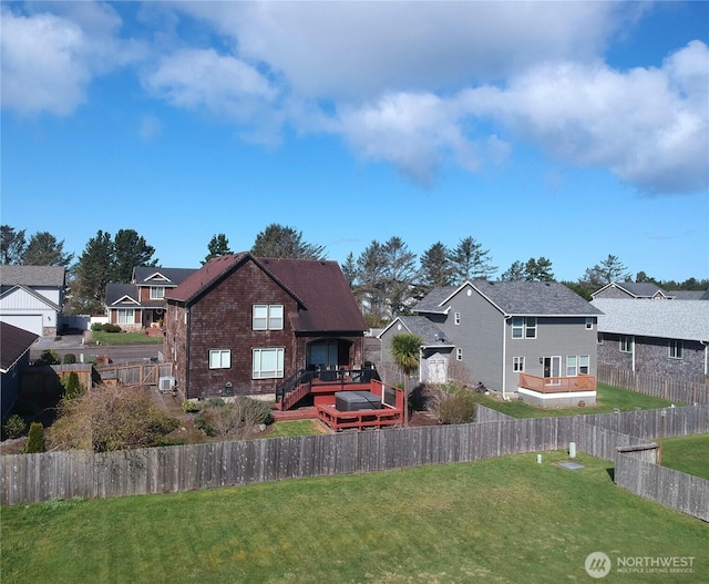 rear view of property with fence, a residential view, a deck, and a yard