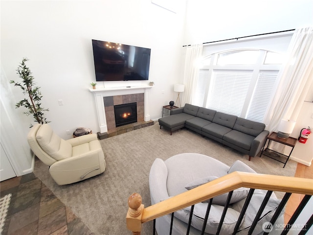 living area with a tile fireplace and baseboards