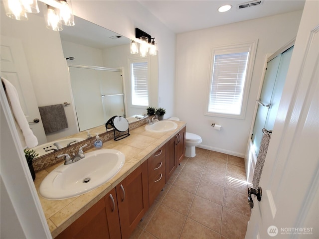 full bathroom featuring an enclosed shower, double vanity, and a sink