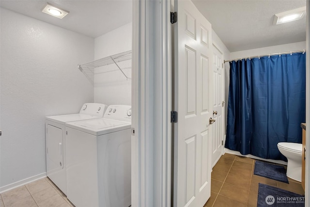 12519 SE 41st Pl Unit B103, Bellevue, WA 98006 - laundry area with light tile patterned floors, baseboards, separate washer and dryer, and laundry area