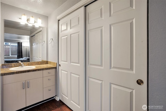 12519 SE 41st Pl Unit B103, Bellevue, WA 98006 - bathroom featuring wood finished floors, vanity, and ensuite bathroom
