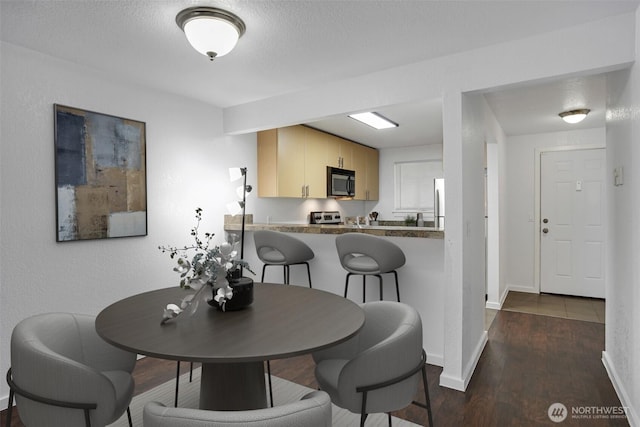 12519 SE 41st Pl Unit B103, Bellevue, WA 98006 - dining space featuring baseboards and dark wood-style floors