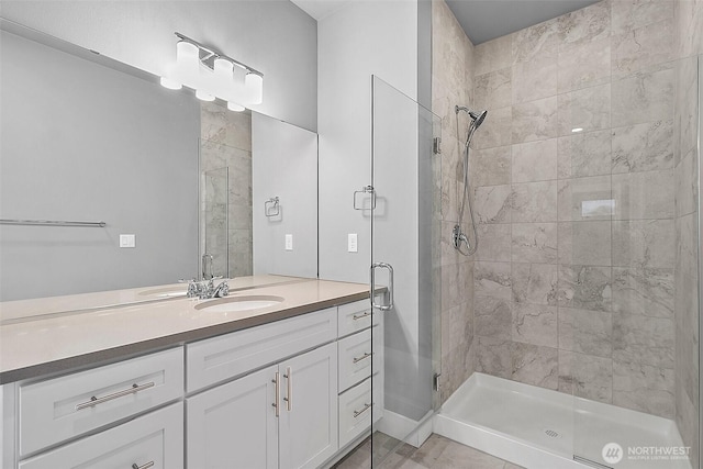 bathroom with a shower stall and vanity