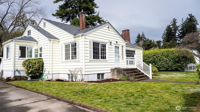 view of front of house featuring a chimney and a front yard