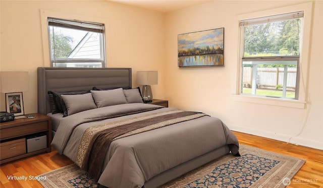 bedroom featuring wood finished floors and multiple windows