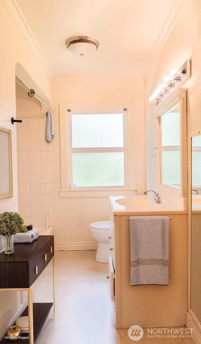 bathroom with vanity, ornamental molding, toilet, walk in shower, and baseboards