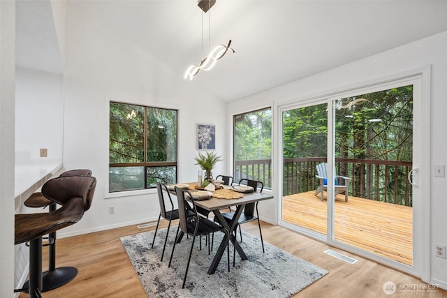 dining area with baseboards, plenty of natural light, light wood-style flooring, and visible vents