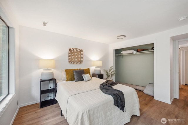 bedroom with baseboards, a closet, and wood finished floors