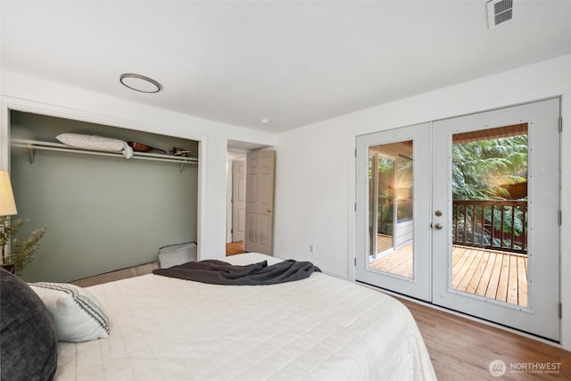 bedroom with visible vents, a closet, wood finished floors, access to exterior, and french doors