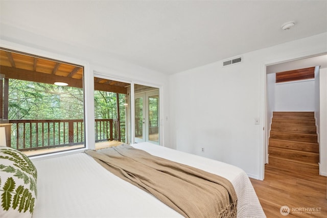 bedroom featuring visible vents, light wood-type flooring, and access to exterior