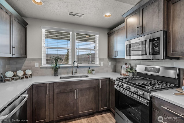 705 Ava St, Walla Walla, WA 99362 - kitchen with stainless steel appliances, a sink, plenty of natural light, dark brown cabinetry, and a textured ceiling