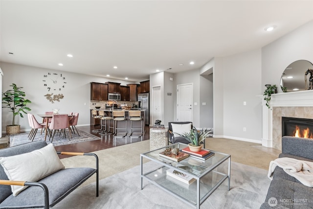 living room featuring a tile fireplace, baseboards, and recessed lighting