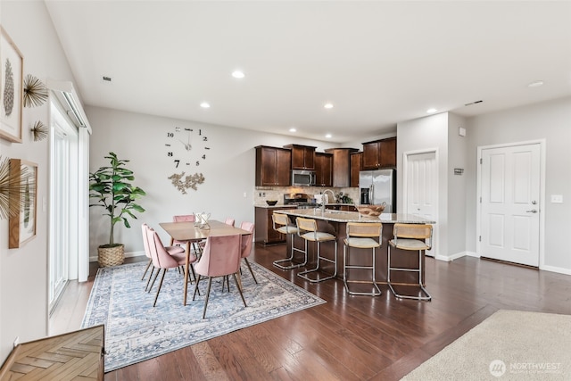 dining space with baseboards, recessed lighting, and dark wood-type flooring