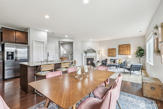 dining area featuring a fireplace, dark wood finished floors, and recessed lighting