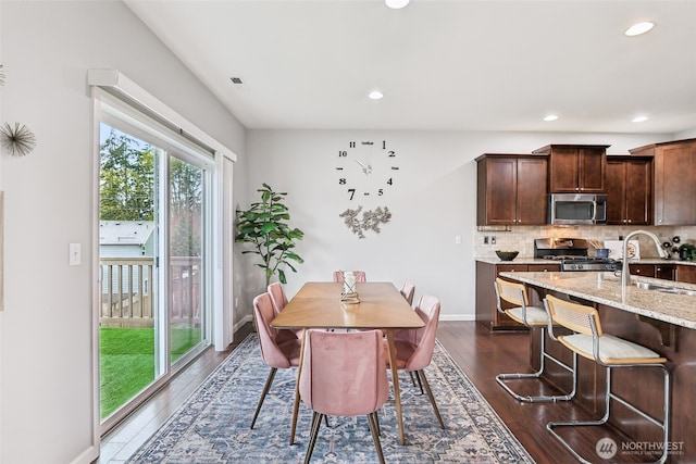 dining space featuring dark wood finished floors, baseboards, and recessed lighting
