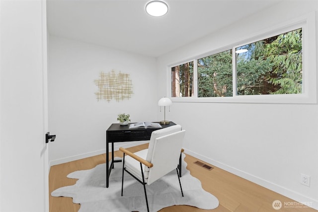 home office featuring visible vents, baseboards, and wood finished floors