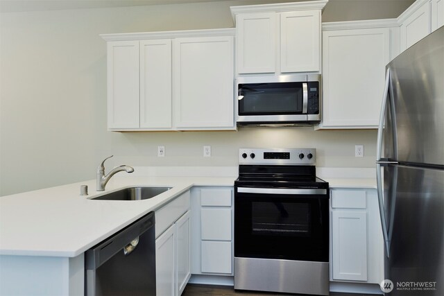 1208 E 53rd St, Tacoma, WA 98404 - kitchen featuring light countertops, a sink, white cabinetry, appliances with stainless steel finishes, and a peninsula