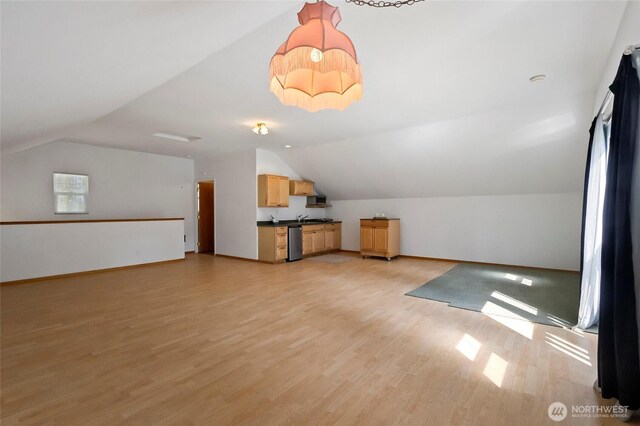 additional living space featuring light wood-style floors, vaulted ceiling, and baseboards