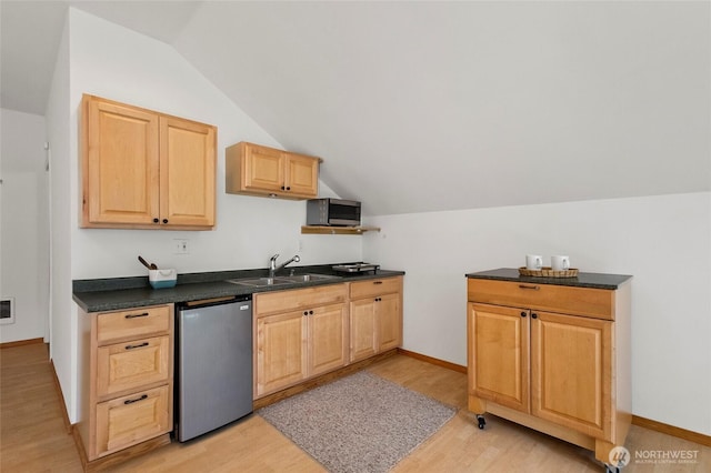 kitchen featuring vaulted ceiling, refrigerator, light wood-type flooring, and a sink
