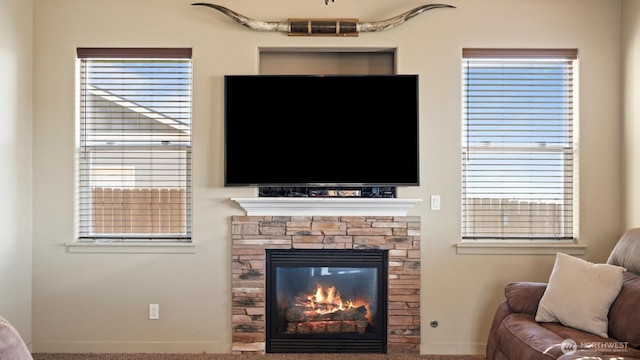 living room featuring a stone fireplace and visible vents