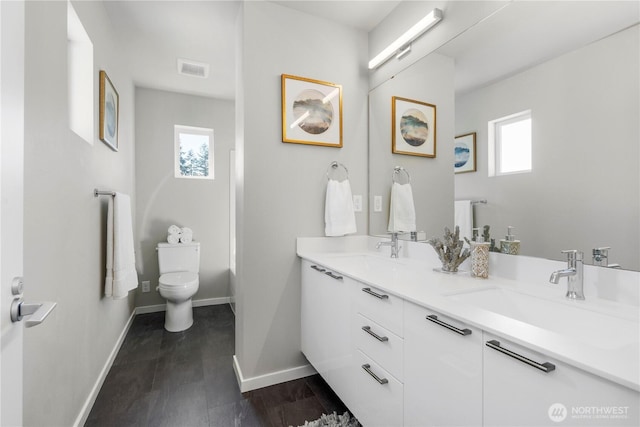 13815 Brookdale Ln E Unit 107, Tacoma, WA 98445 - bathroom with toilet, a sink, visible vents, and a wealth of natural light