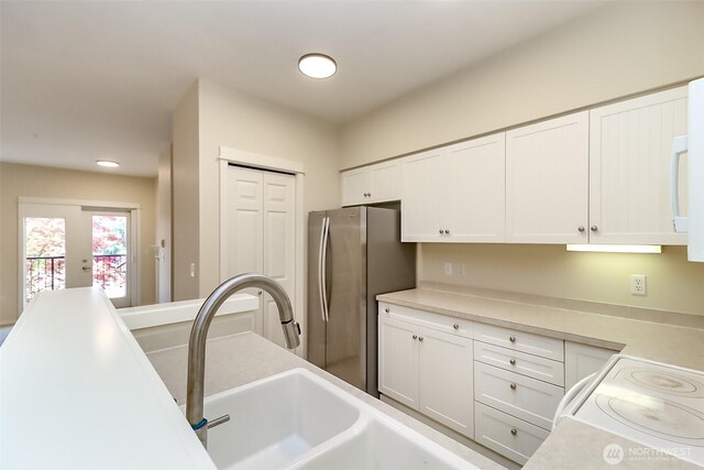 15026 40th Ave W Unit 7-203, Lynnwood, WA 98087 - kitchen featuring freestanding refrigerator, range, light countertops, white cabinets, and a sink