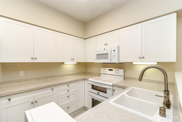 15026 40th Ave W Unit 7-203, Lynnwood, WA 98087 - kitchen featuring light countertops, a sink, white cabinets, and white appliances