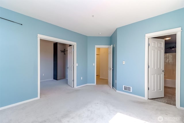 15026 40th Ave W Unit 7-203, Lynnwood, WA 98087 - unfurnished bedroom with a walk in closet, visible vents, light carpet, and baseboards