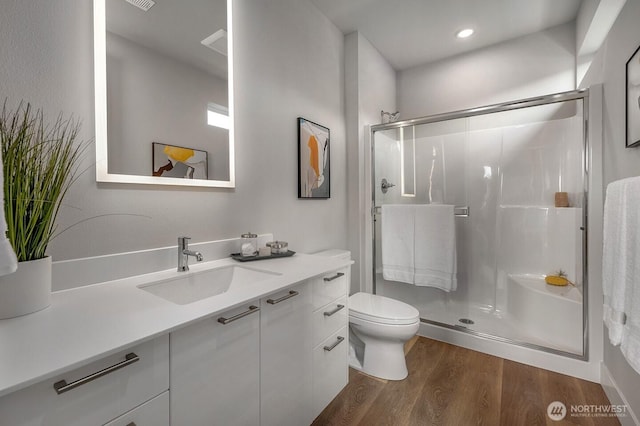 1515 141st St E Unit 72, Tacoma, WA 98445 - full bath featuring wood finished floors, a shower stall, vanity, toilet, and recessed lighting