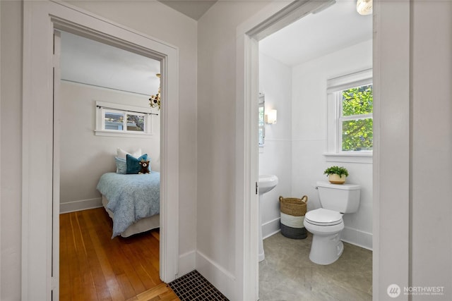 bathroom featuring baseboards, hardwood / wood-style floors, and toilet