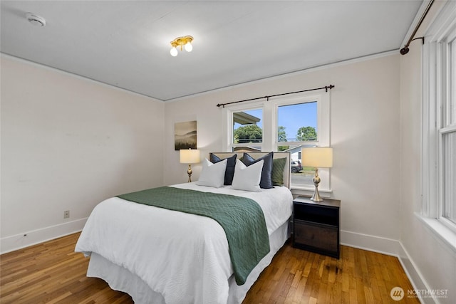 bedroom featuring baseboards and hardwood / wood-style flooring