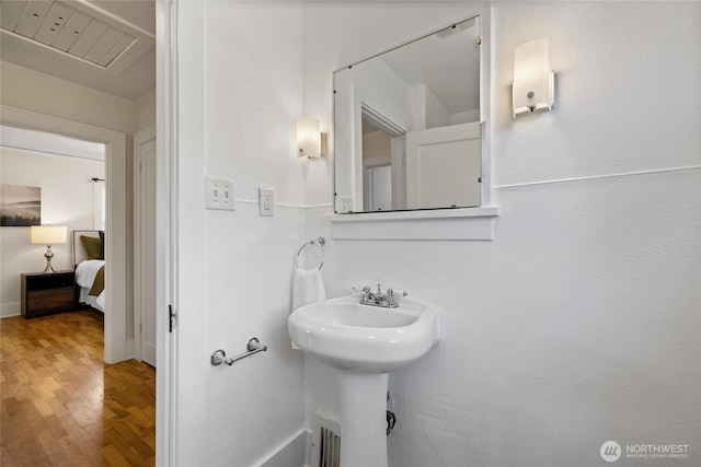 bathroom with baseboards, a sink, and wood finished floors